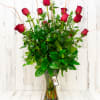 One dozen long stem Premium roses with fresh greens in a tall