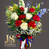 Bouquet of red and white roses with blue flowers in a glass vase