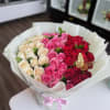 Bouquet of pink, red, and cream roses in white wrapping