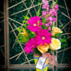 Gerber daisies and roses along with other seasonal flowers arranged in a