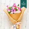 Bouquet of pink and white roses wrapped in brown paper and burlap