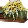 Yellow and white floral casket spray with a Holy Bible card