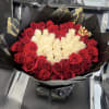 Bouquet of red and white roses wrapped in black paper with gold accents