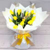 Yellow tulip bouquet wrapped in white paper with a gold ribbon