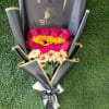 Bouquet of pink roses and yellow daisies wrapped in black paper