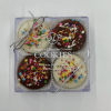 Box of four chocolate-covered cookies with colorful sprinkles