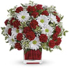 Red carnations and white daisies in a clear square vase