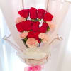 Bouquet of red roses and pale pink carnations wrapped in blush paper