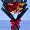Bouquet of red roses wrapped in black paper with a red ribbon