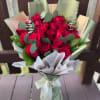 Bouquet of red roses wrapped in pale green and white paper