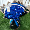 Bouquet of bright blue roses wrapped in black paper with a white ribbon