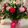 An elegant floral arrangement featuring a mix of pink roses, hot pink