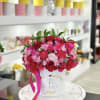 Pink and red rose arrangement in a white hat box with a ribbon