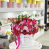 Pink and red rose arrangement in a white hat box with a ribbon