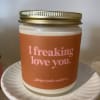 Orange-labeled candle in a glass jar with a gold lid