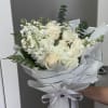 Bouquet of white roses and white filler flowers wrapped in white paper