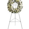 White floral funeral wreath on a standing easel