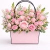 a soft garden -style arrangement in delicate shades of pink featuring roses