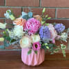 Pastel arrangement of roses, peonies, ranunculus and hyacinth in a pink ceramic vase