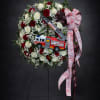 Firefighter-themed rose wreath with a toy fire truck and ribbon on a stand