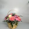 Basket of pink, cream, and lavender roses with baby's breath