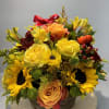 Basket arrangement with yellow roses, sunflowers, and orange blooms