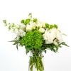 White and green mixed flower arrangement in a clear glass jar vase