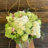 Lime green and white floral arrangement in a clear glass vase