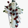 Designed in a cross shape with fresh red roses and soft greenery