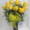 Yellow roses in a clear glass vase with a yellow ribbon