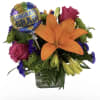 A single bold orange lily takes center stage in this graduation flower