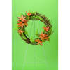 Circular floral wreath with orange lilies on a wire stand