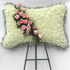 White floral funeral spray with pink roses on an easel
