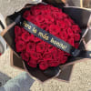 Bouquet of red roses wrapped in black paper with a ribbon
