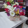Mixed bouquet with lilies, roses, and daisies in a pink box