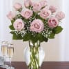 Pink roses arranged in a clear glass vase with baby's breath