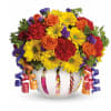 Colorful bouquet of roses, daisies, and carnations in a white vase with curling ribbons