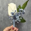 White rose boutonni&egrave;re with Dusty-blue baby's breath and green leaves, wrapped with