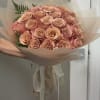 Bouquet of peach roses wrapped in translucent paper