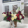 Basket arrangement of red and white roses with daisies