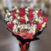 Bouquet of red roses with gold-wrapped chocolates and white baby's breath