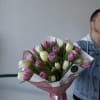Bouquet of pink, white, and yellow tulips wrapped in pink paper