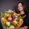Large bouquet of roses and sunflowers wrapped in paper