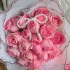 Bouquet of pink roses wrapped in decorative paper with a pearl bow