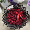Bouquet of deep red roses wrapped in black paper with a red ribbon