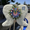 White floral heart wreath on a stand with a sports club emblem