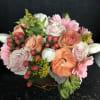 Mixed bouquet with pink roses, peach blooms, and pink daisies in a basket