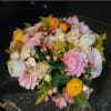 Bouquet of pink, cream, and yellow flowers with berry accents