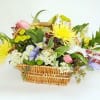 Mixed flower arrangement in a wicker basket with yellow and pink blooms