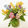 Mixed bouquet with roses, lilies, and snapdragons in a glass vase